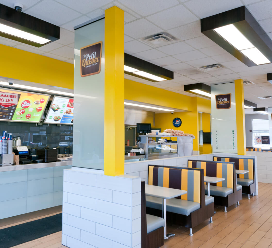 Inside view of a restaurant's dining area with stripped yellow and brown benches