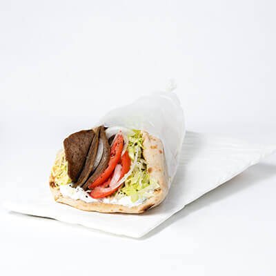 Sandwich on pita bread, with gyros meat, lettuce, tomatoes and onions, on a white background