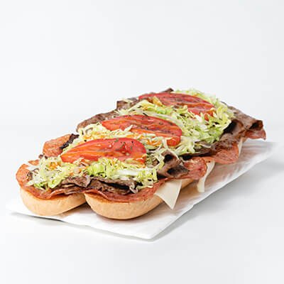 Submarine sandwich with cheese, pepperonis, steak, lettuce, tomatoes, on a white background