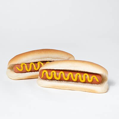 Two steamed hot dogs with a drizzle of mustard, on a white background