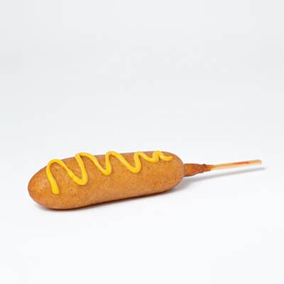 Cooked pogo with a drizzle of mustard, on a white background