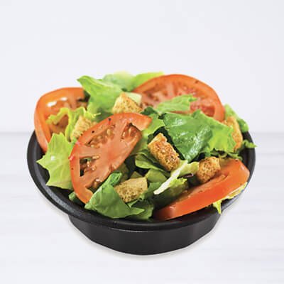 Salad in a black container, with lettuce, tomatoes, onions, croutons and ranch dressing, on a white background