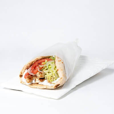 Sandwich on pita bread, with grilled chicken, lettuce, tomatoes and onions, on a white background